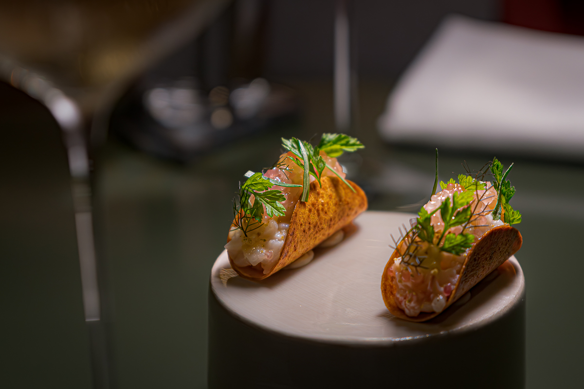 taco de raiz de aipo estaladiço, recheado com tártaro de lagostim, lima-caviar, baunilha, laranja e funcho.